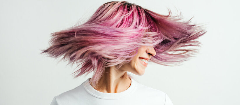 Positive and funny plus size model with white blank t-shirt and pink hear, empty grunge wall background. Shaking her colored hair