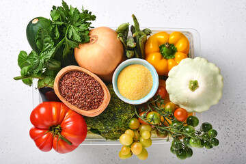 Assortment of fresh fruits and organic multicolored rainbow vegetables on gray concrete background. Food cooking and healthy clean food background and mock up.