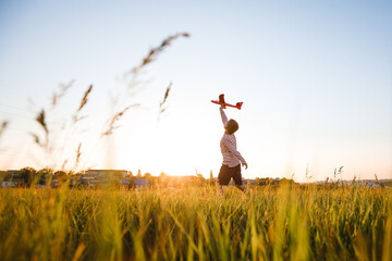 School-age boy launch a toy airplane.