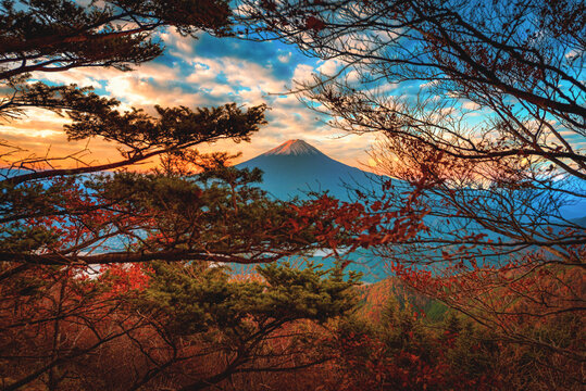 Landscape image of Mt. Fuji over Lake Kawaguchiko with autumn foliage at sunrise in Fujikawaguchiko, Japan.