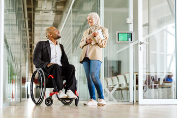 Middle eastern colleagues smiling and talking while meeting in office