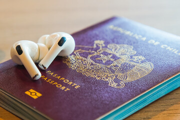 a red passport on a desk with a pair of 
headphones
