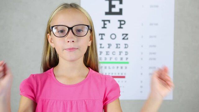 girl in a good mood tries on glasses for vision correction at an ophthalmologist