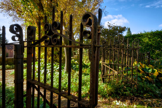 Close up of the entrance of an iron gate in autumn