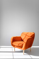 stylish brown armchair with wooden legs on a gray background