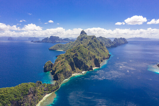 Beautiful coral reef, boats and a clear ocean on Matinloc Island, Bacuit Archipelago, El Nido, Palawan, Philippines. Aerial drone view.