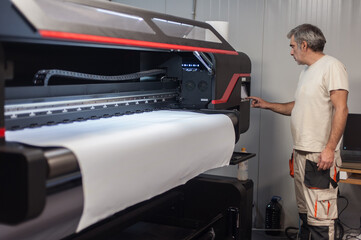 Technician operator works on large premium industrial printer plotter machine