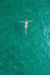 Young nude beautiful, sexy woman with naked breast lying on sea, ocean water. Summer. View from above. Top view, copter