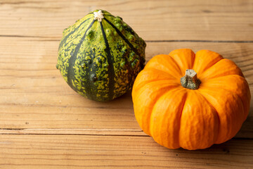 Top view of two halloween pumpkins, on rustic wooden table, horizontal, with copy space