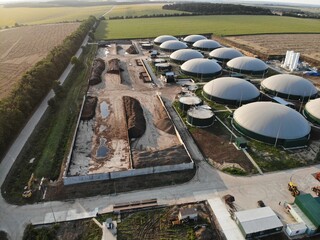 Biogas complex on nature landscape. Agricultural plant for biomass production on green field....
