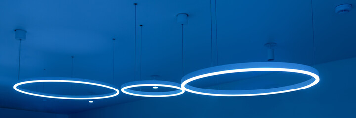 Ceiling with round modern LED lamps. Suspended fluorescent lights under the ceiling. Careful energy...