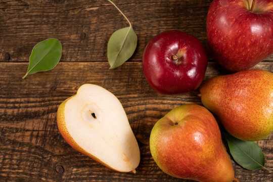 Fresh fruit lying on a wooden table.Apples, pears, Fresh leaves on a wooden background.