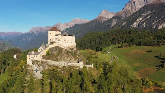 Aerial drone footage of the famous Tarasp castle near Scuol in the alps in Canton Graubunden in Switzerland on a sunny summer day. Shot with a rotation motion