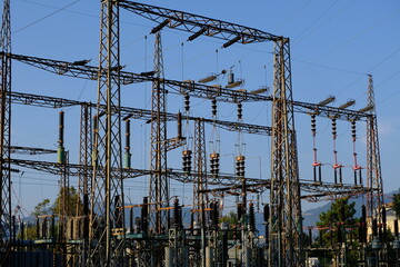 Electric power. High voltage electrical pylons. Electricity transformation and distribution center. Silouette on blue sky. 