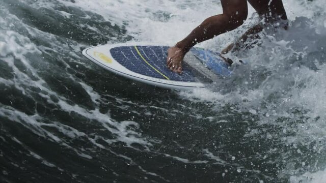 Close up view slow-motion of surfer's legs on board.Wave surfing in Dubai, UAE, Persian Gulf. 4K footage