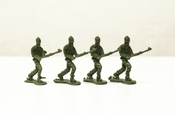 The isolated image of a group of green plastic toy soldiers