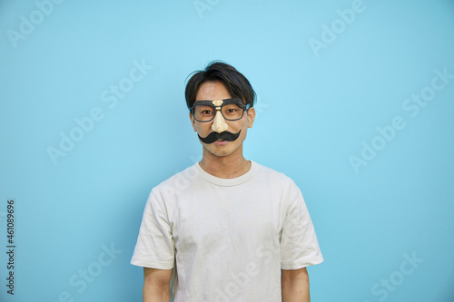パーティーグッズの髭メガネをかけるアジア人男性 Wall Mural Photok