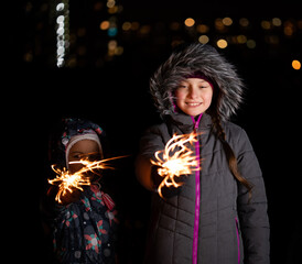 Children with Bengal lights outdoors at night in winter