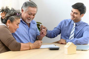 Asian senior couple feeling happy and pleasant after received advice about family financial planning or real estate insurance or health insurance from professional financial planner staff at home.