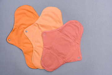 Reusable cloth menstrual pads that are biodegradable, eco friendly against grey background with copy space 