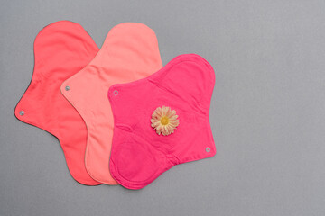 Reusable cloth menstrual pads that are biodegradable, eco friendly against grey background 