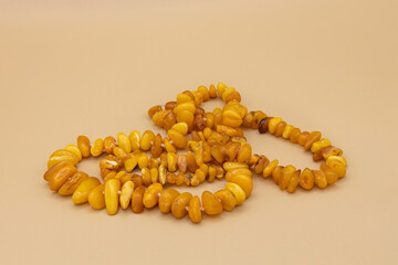 Beautiful amber beads, two persimmons on a natural background. Golden fall composition