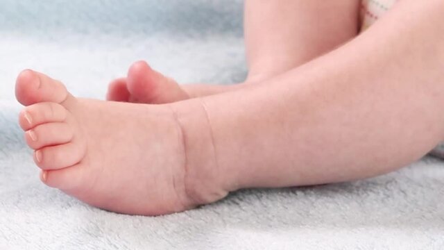 Close-up of moving legs and feet of a small baby