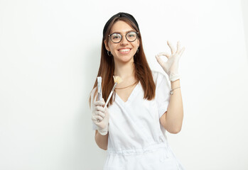 Portrait of young attractive doctor beautician with brushes on white background