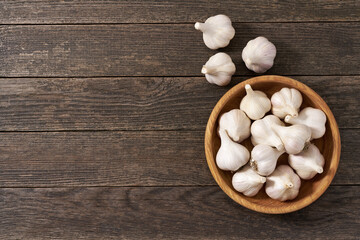 fresh garlic on a rustic wooden table, copy space for text. Top view.