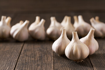 Raw whole garlic on a wooden table, selective focus.