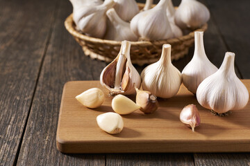 Peeled and unpeeled garlic cloves on a cutting board.