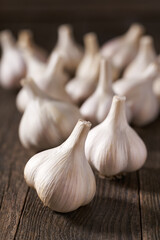 Raw whole garlic on a wooden table, selective focus.