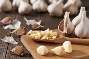 Chopped garlic in a wooden spoon on a cutting board, selective focus.