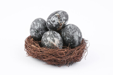 Gray marble painted Easter eggs in nest on white background