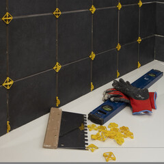 Pose d'un carrelage mural noir dans une salle de bains © hcast