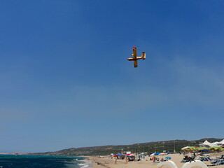 Löschflugzeug über einem Strand auf Sardinien