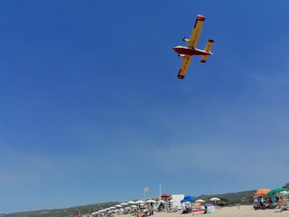 Löschflugzeug über einem Strand auf Sardinien