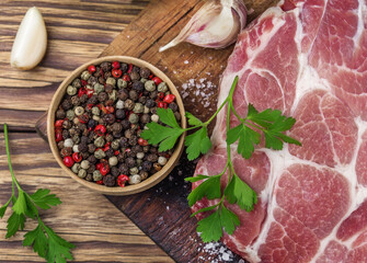 Raw pork steak with pepper and garlic