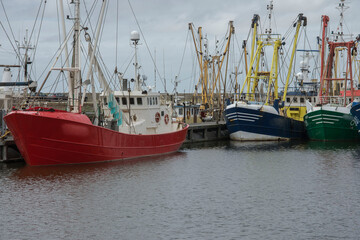 fishing boats laying in the harbor of lauwersoog on a clouded sunday in summer