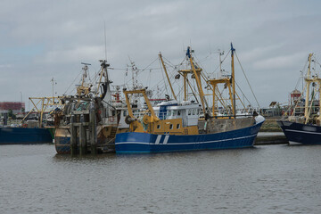 fishing boats with nets laying in the harbor of Lauwersoog on a sunny sunday