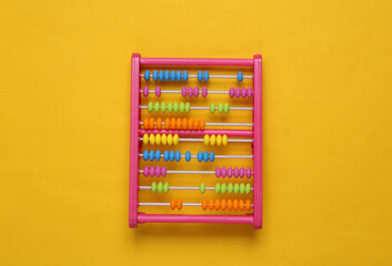 Childrens toy abacus on yellow background