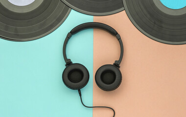Retro vinyl records and stereo headphones on pink blue pastel background. Top view. Flat lay