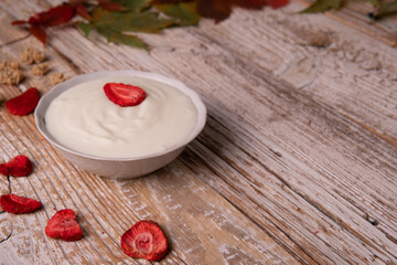 Healthy breakfast on wooden table. natural yogurt with dehydrated strawberries on a wooden background top view