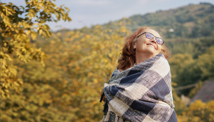 Beautiful senior mature happy smiling woman in autumn garden of her country house