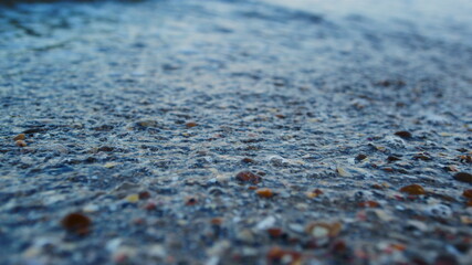 Macro blue sea water splashing seashell sand beach in slow motion. Sea waves