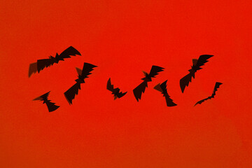Paper-cut bats in orange neon light. Halloween theme