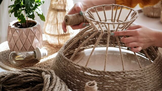 Close up Woman makes handmade diy lamp from jute rope
