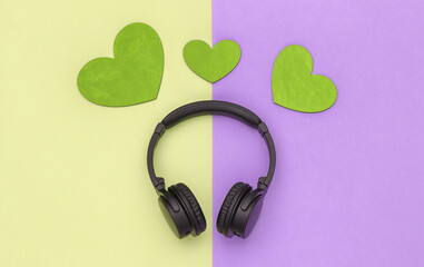 Music lover. Stereo headphones and hearts on colored pastel background. Top view