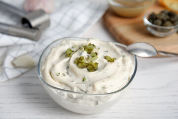 Tasty tartar sauce on white wooden table, closeup