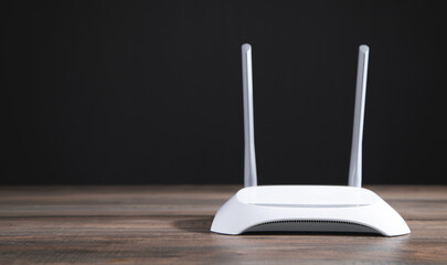 Modern wifi router on the wooden table. - obrazy, fototapety, plakaty